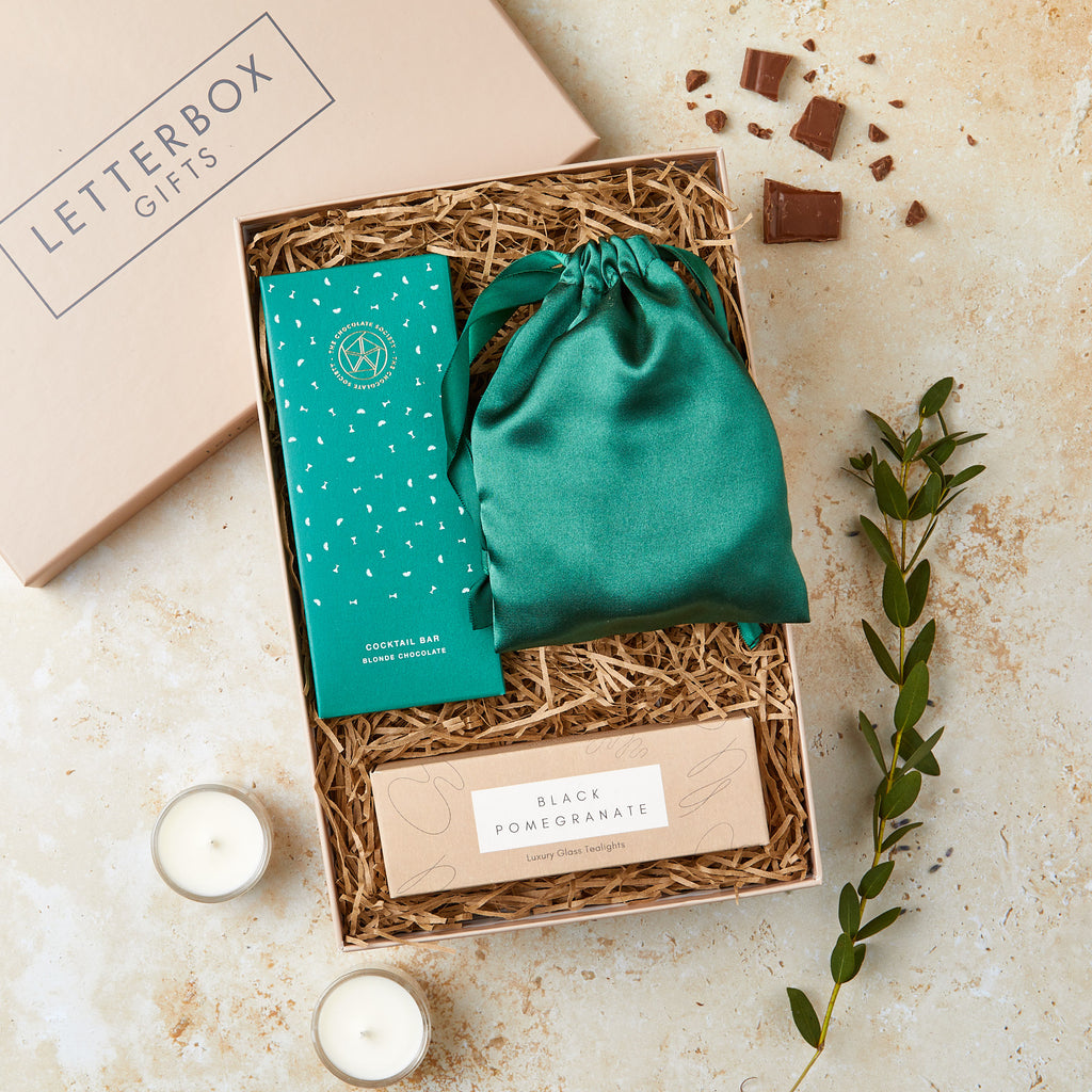 Letterbox-friendly gift set containing green silk eye mask, cocktail chocolate bar and black pomegranate tealights